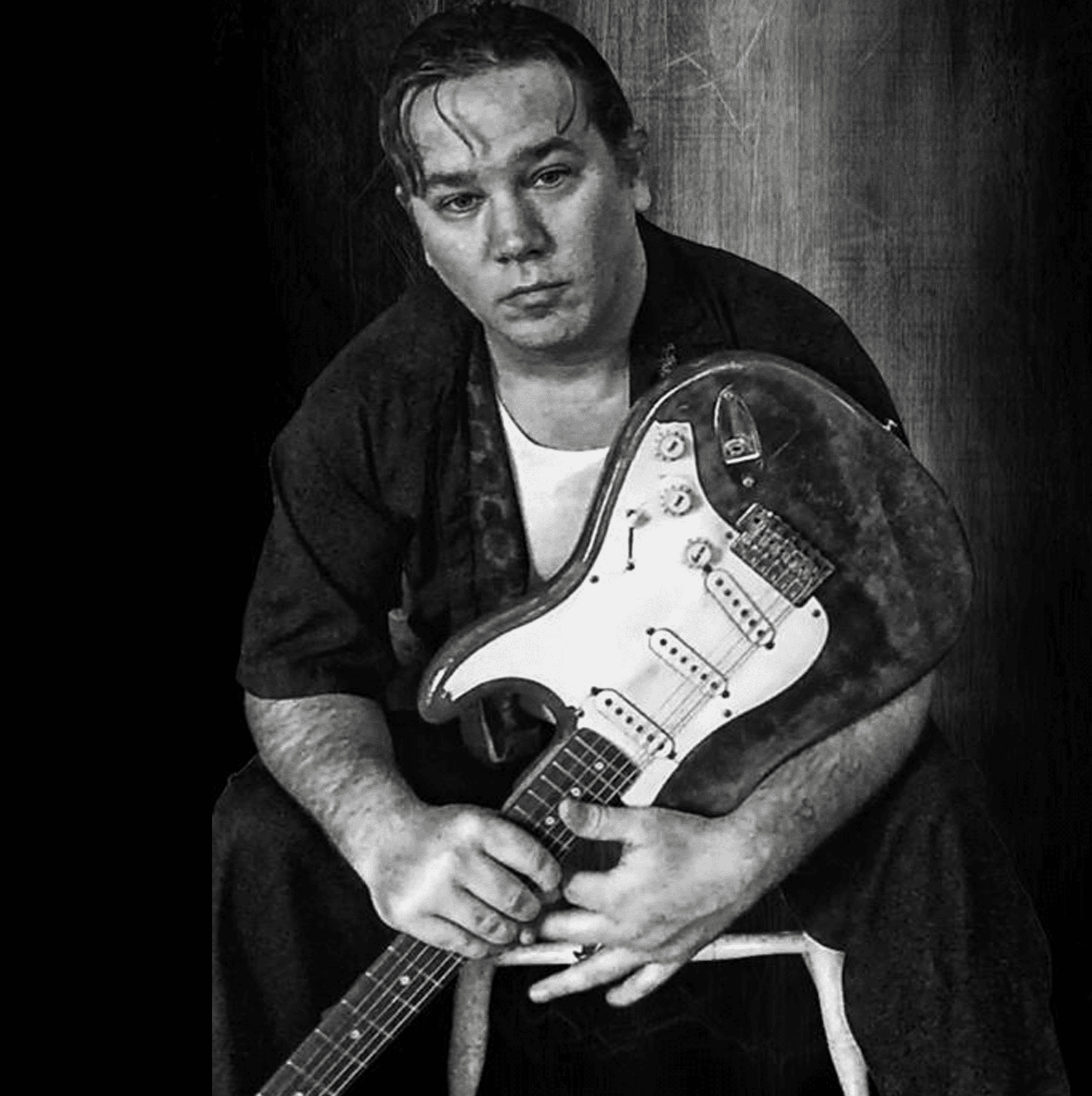 Gordon James seated with Stratocaster